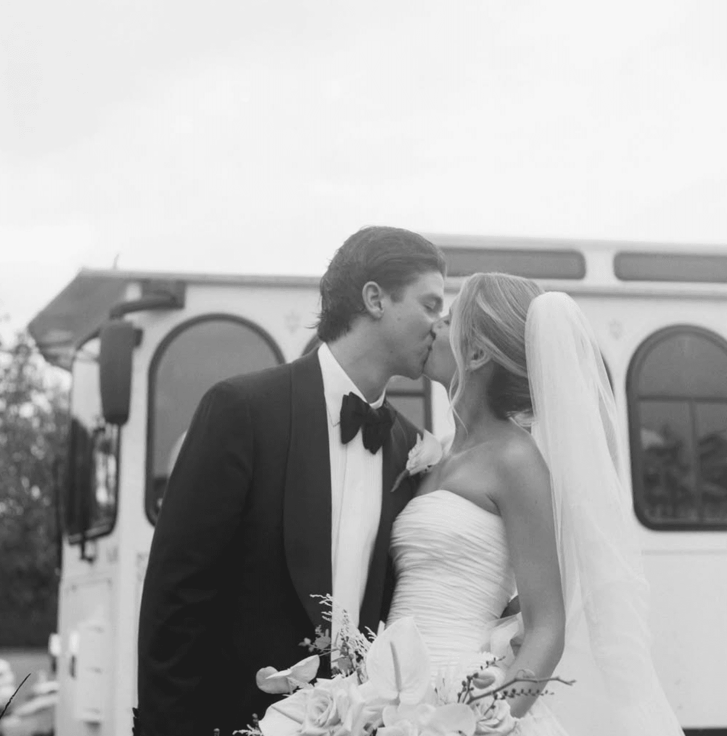 Bride and groom kiss by the trolley