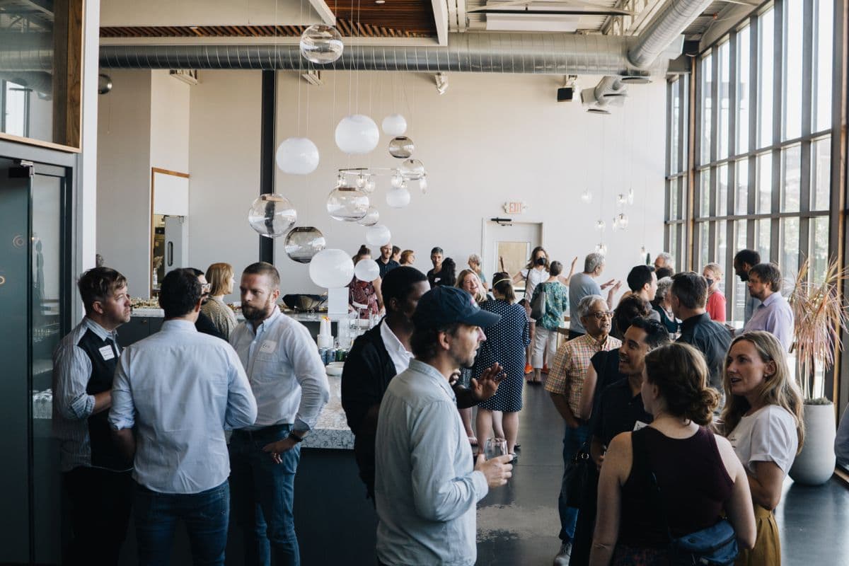 Guests networking at a corporate reception in a glass-walled venue