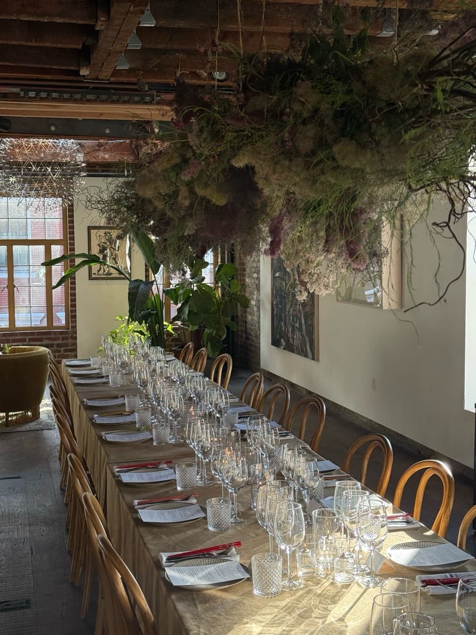 A long dinner table set beneath hanging florals for the Nike executive team dinner