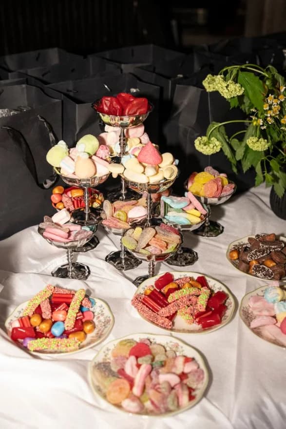 A dessert table of candy displays on tiered silver stands