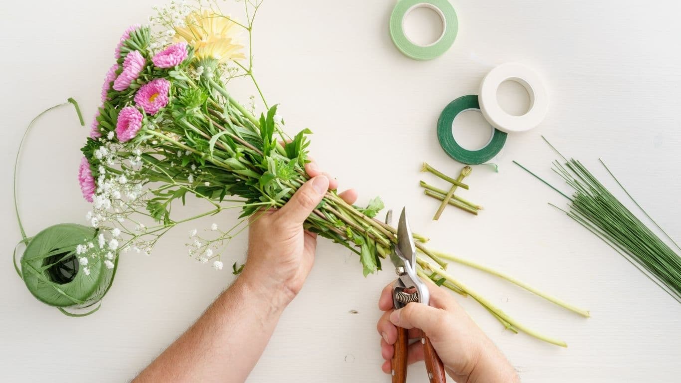 A florist trimming stems while building a bouquet