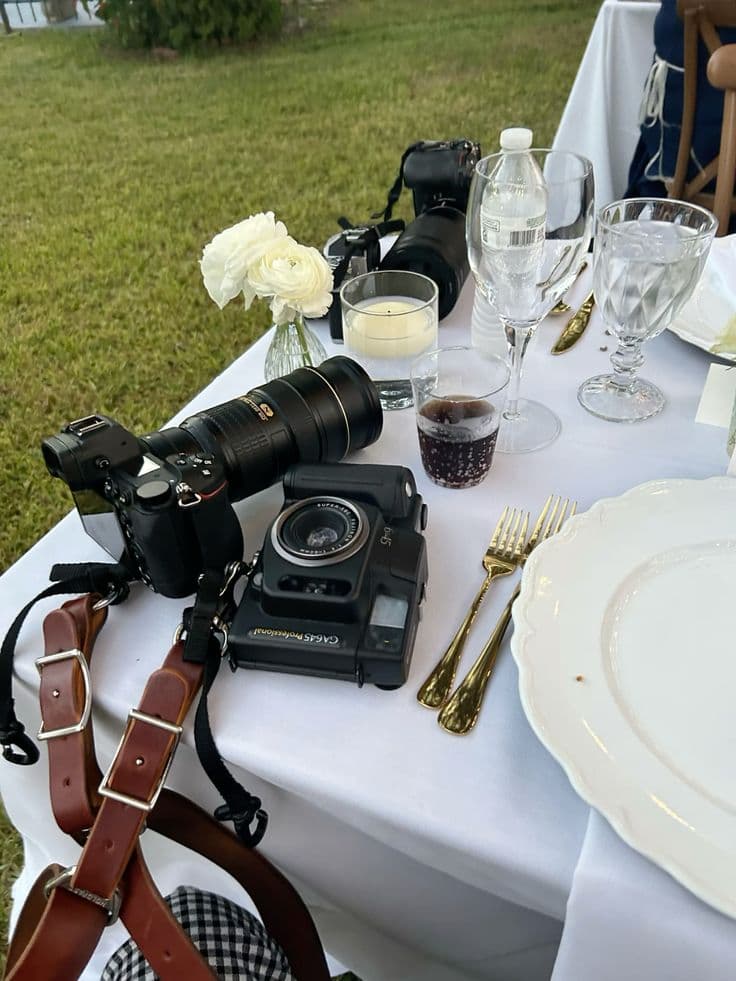 Camera bodies and lenses set down on a reception table