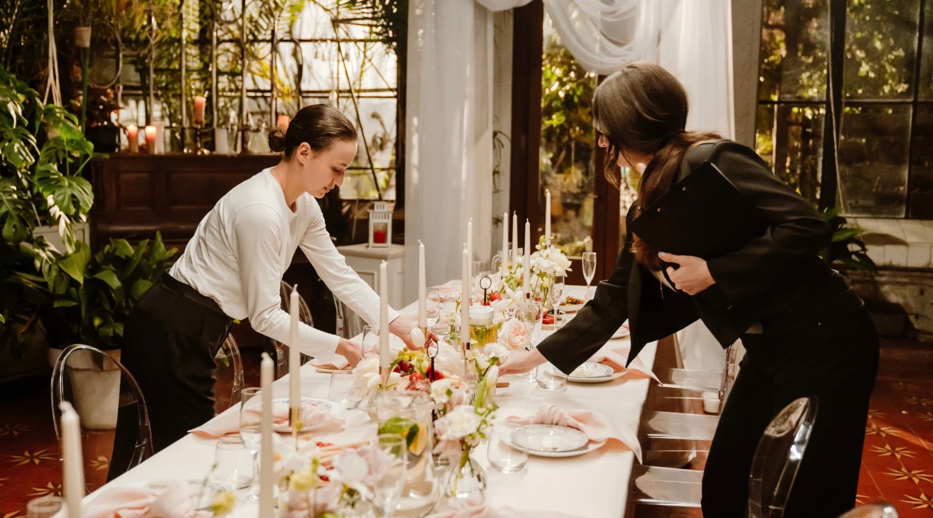 Two coordinators finishing a long banquet table before an event