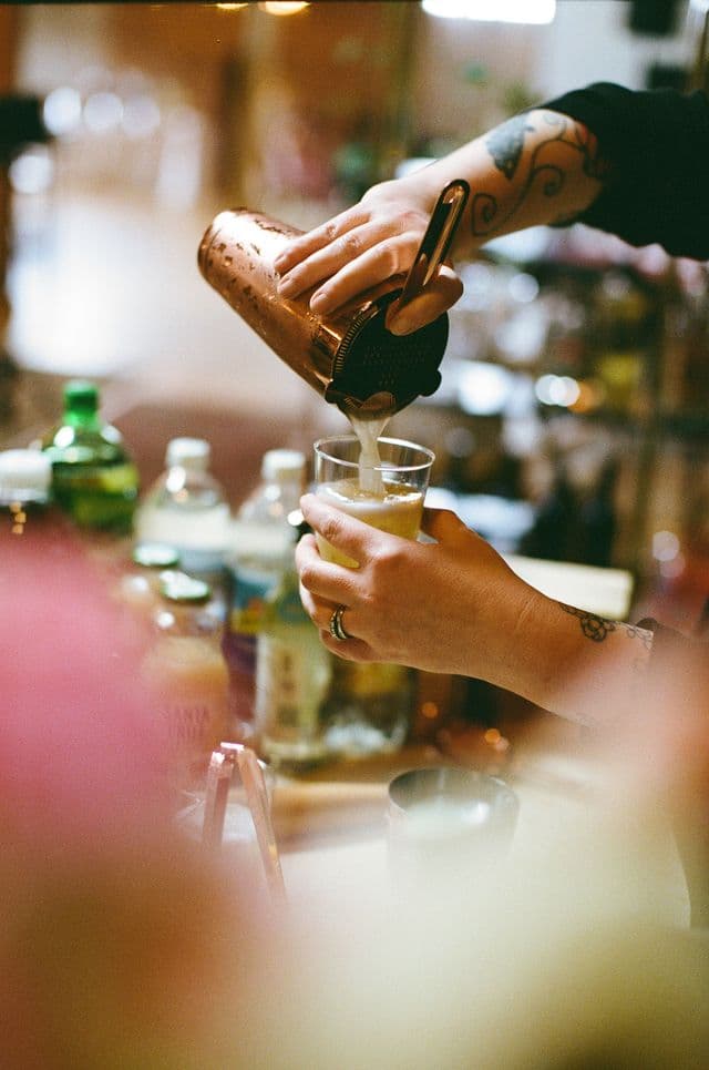 A bartender pouring a cocktail at an event