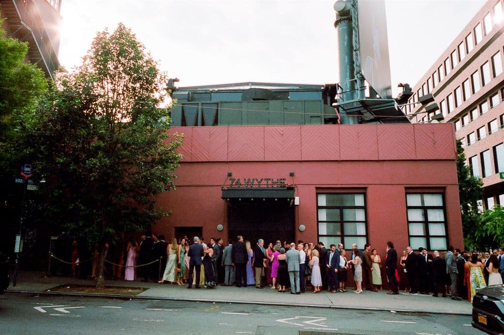 Event guests gathered outside a brick venue at cocktail hour